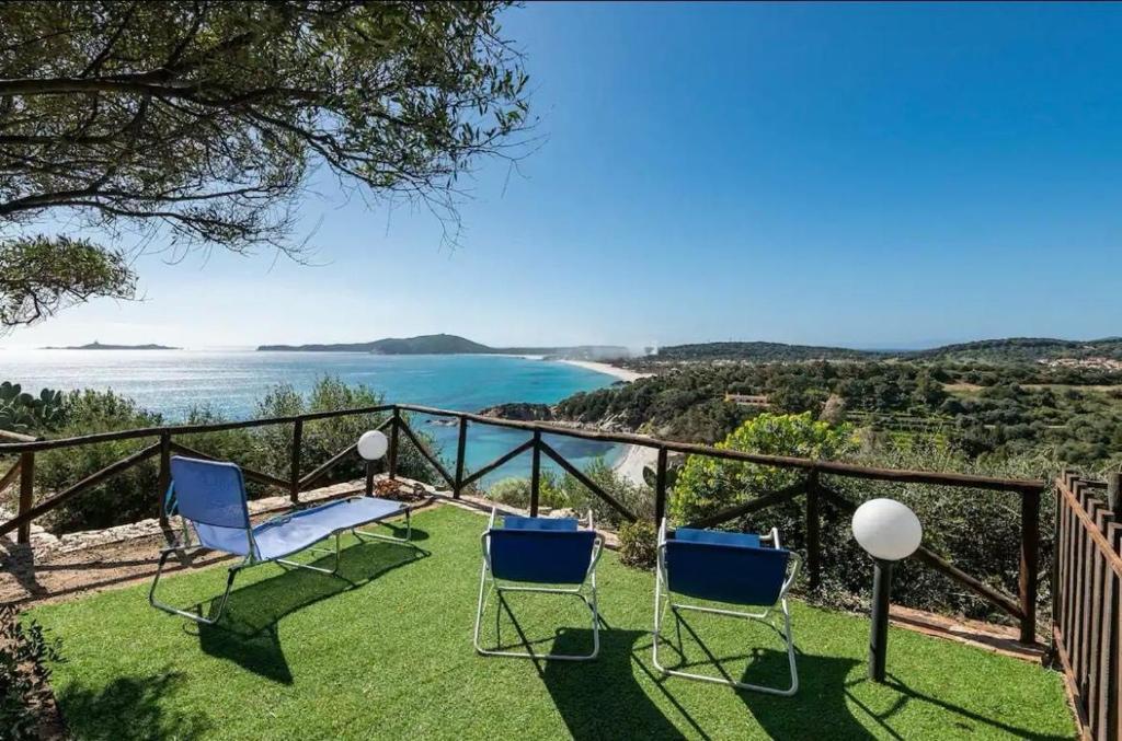 Un balcón con sillas y vista al mar. en Villa Acquamarina a 2 passi dal mare, en Simius