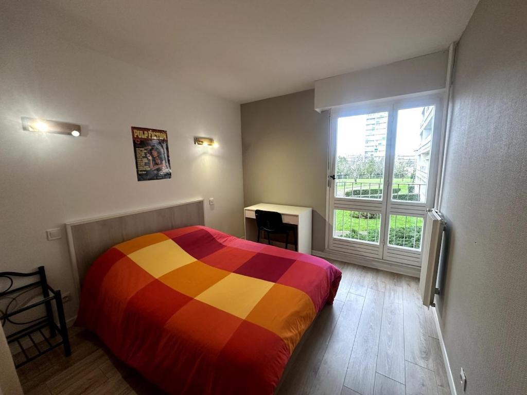 - une chambre avec un lit coloré et une fenêtre dans l'établissement Apartement entier - 8 personnes - Angoulême, à Angoulême