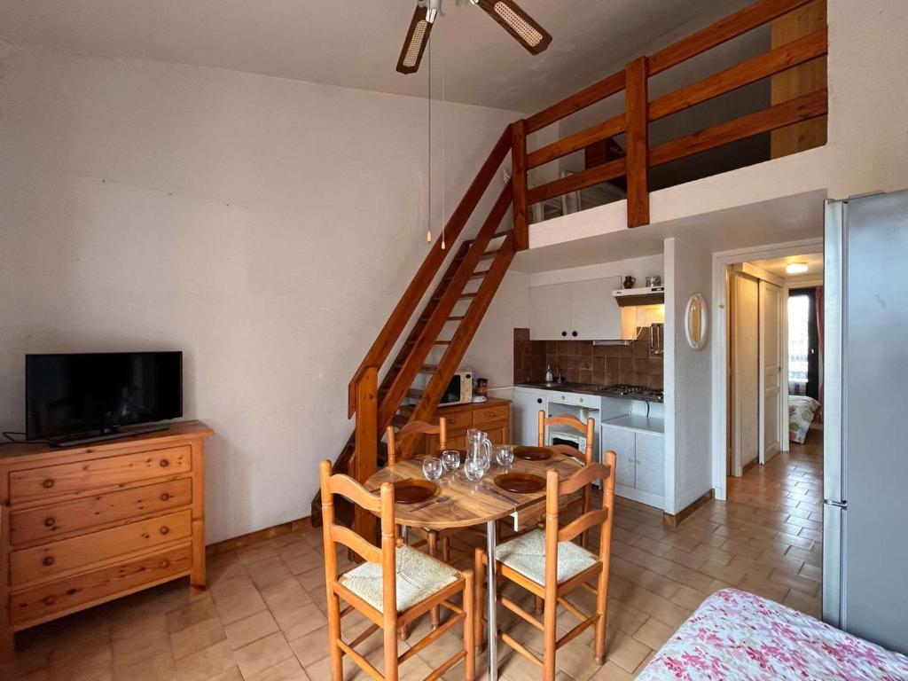 une salle à manger avec une table et une mezzanine dans l'établissement Appartement deux pièces mezzanine Port la Nouvelle PN005-035, à Port-la-Nouvelle