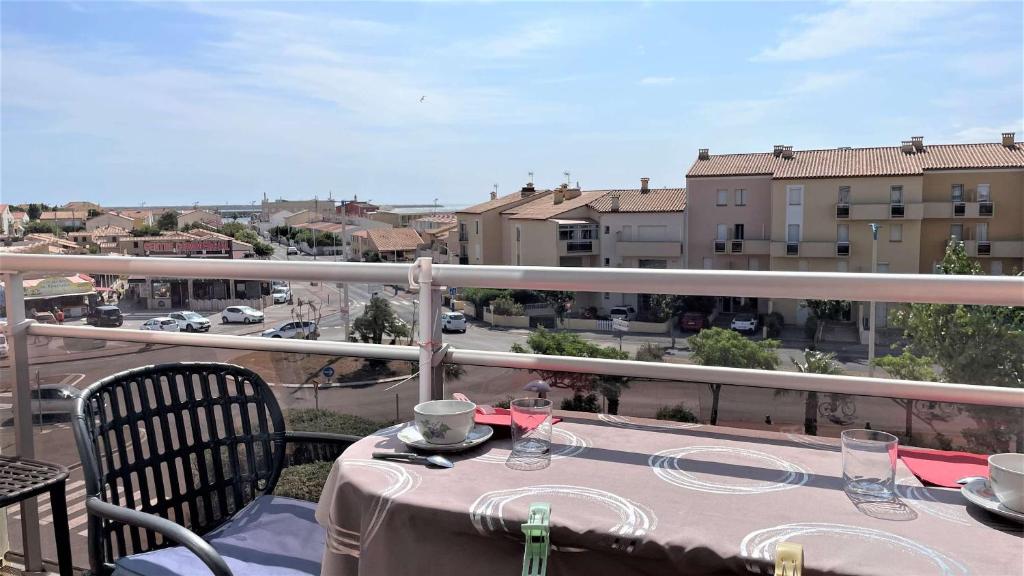 une table sur un balcon avec vue sur une ville dans l'établissement Appartement deux pièces Port La Nouvelle PN020-031, à Port-la-Nouvelle