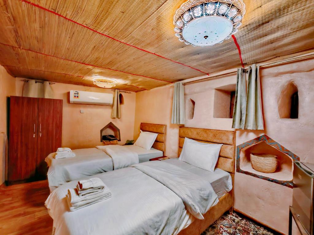 Postel nebo postele na pokoji v ubytování Manazil Inn نزل المنازل