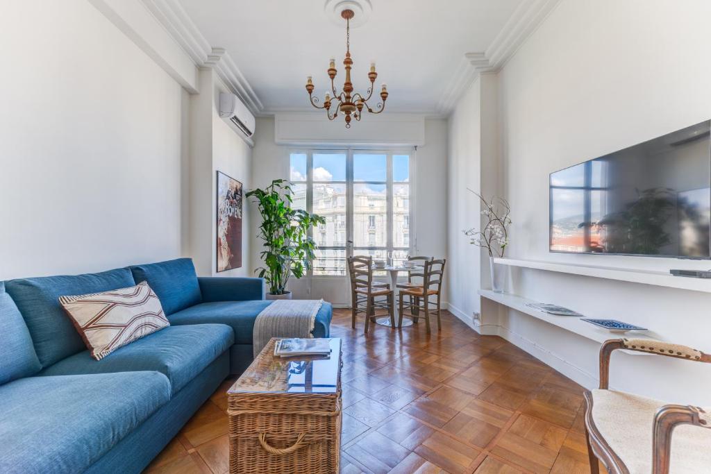 un salon avec un canapé bleu et une table dans l'établissement Elegant Condo with Balconies in the Heart of Nice, à Nice