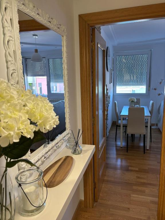 a mirror on a counter with a vase of flowers at El pisuco in Miengo