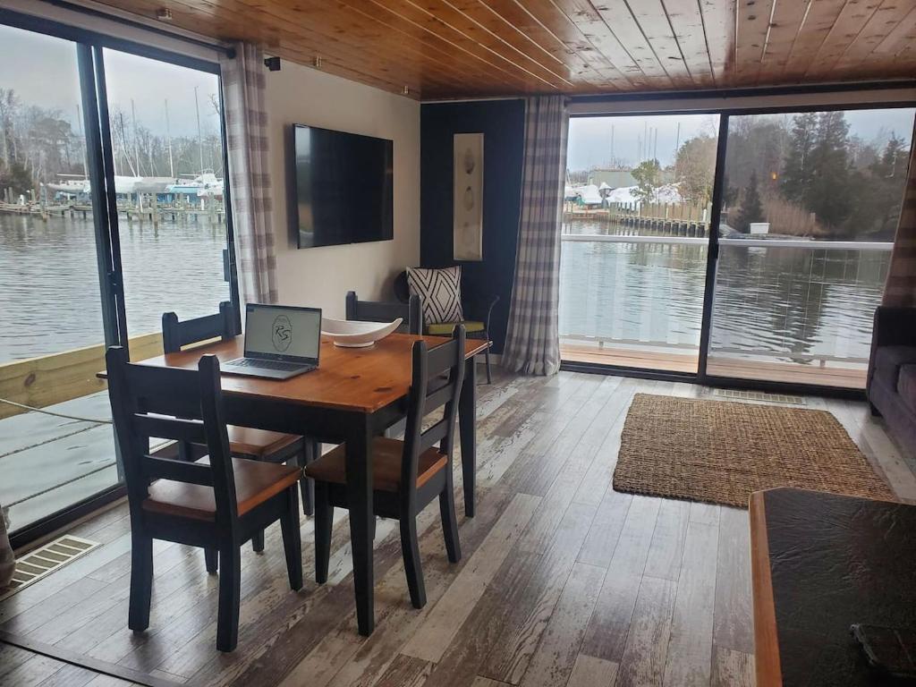 a dining room with a table with a laptop on it at Float and Relax ON the Water Float Home in Forked River