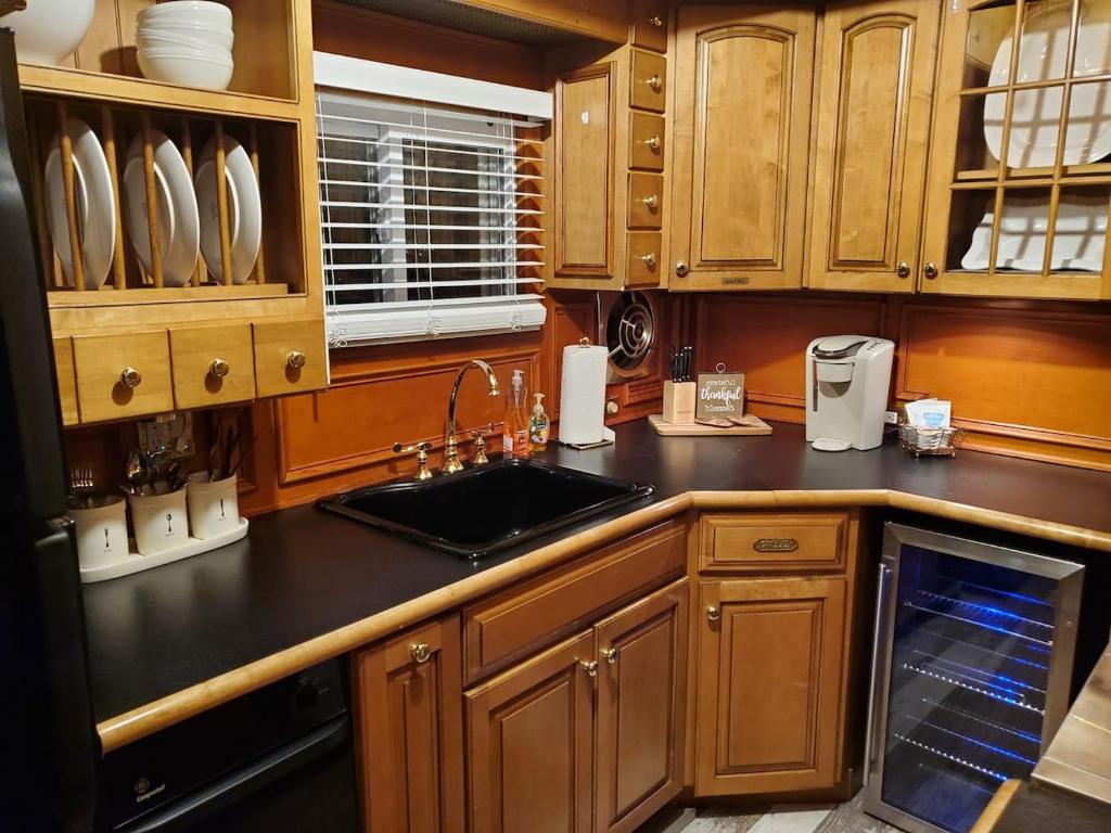 a kitchen with wooden cabinets and a black counter top at Float and Relax ON the Water Float Home in Forked River
