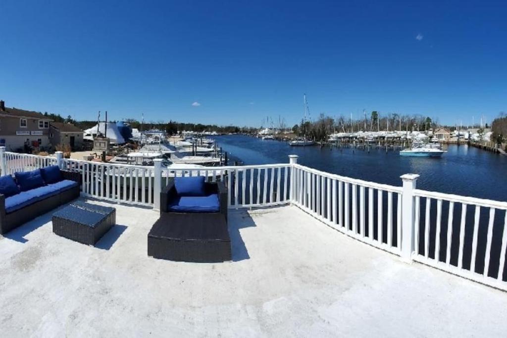 a balcony with a view of a harbor with boats at Float and Relax ON the Water Float Home in Forked River