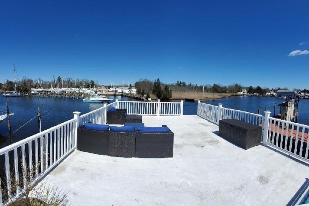 a patio with a white fence and a body of water at Float and Relax ON the Water Float Home in Forked River