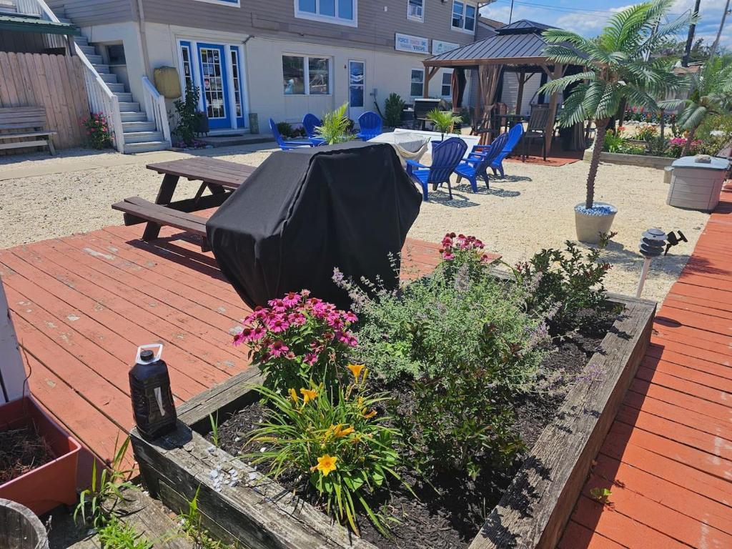 a patio with a picnic table and some flowers at Float and Relax ON the Water Float Home in Forked River