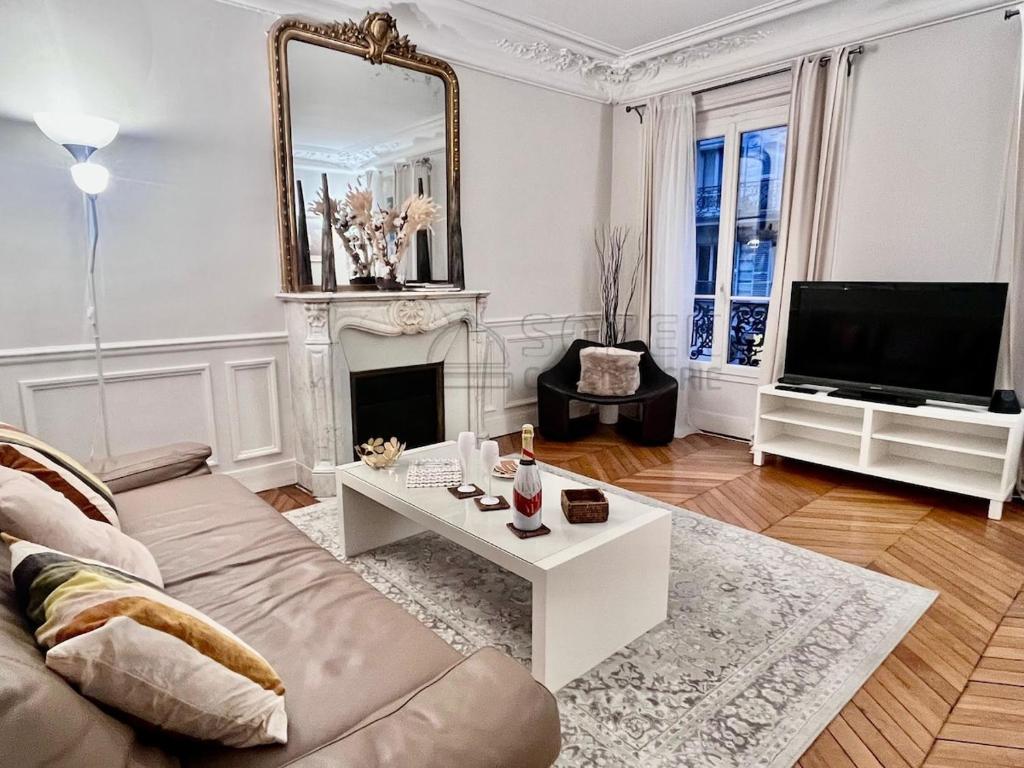 un salon avec un canapé et une cheminée dans l'établissement Haussmannien de Luxe, à Paris