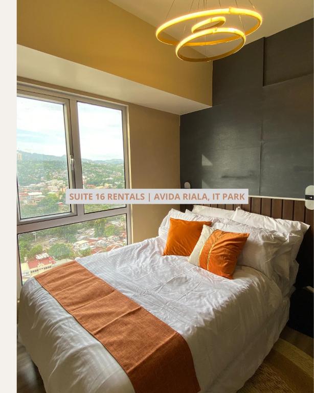 un grand lit dans une chambre avec une grande fenêtre dans l'établissement Cozy Studio Suite in IT Park near Ayala Mall, à Cebu