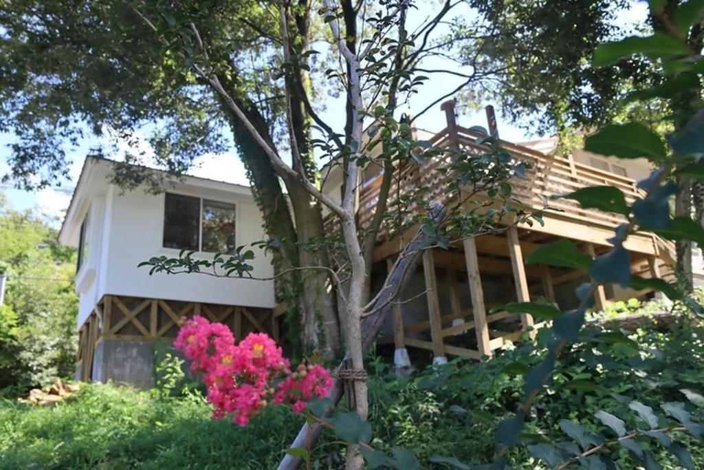 une maison avec des fleurs roses devant elle dans l'établissement Cottage Dejavu & Harvest - Vacation STAY 03241v, à Uwano