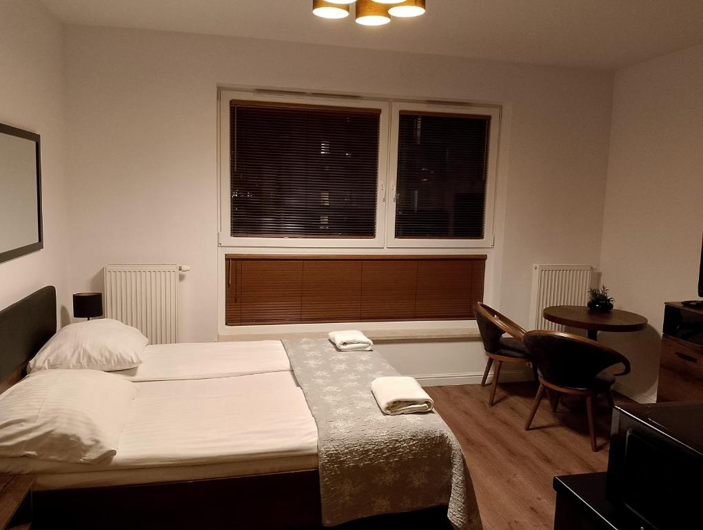 sypialnia z łóżkiem, stołem i 2 krzesłami w obiekcie Apartament Bastion Wałowa Gdańsk w Gdańsku