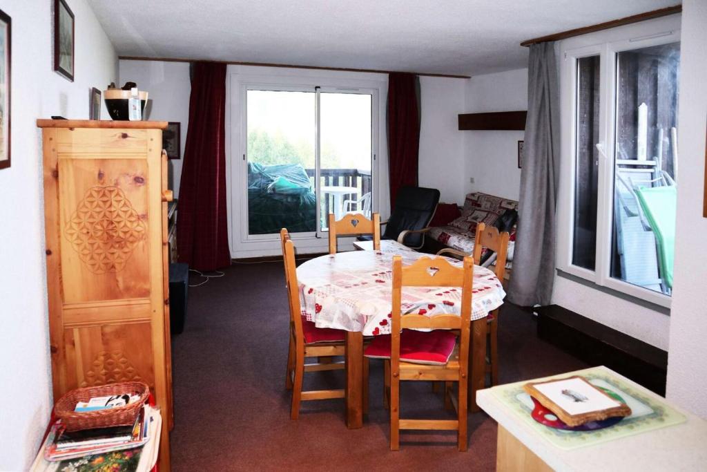 une salle à manger avec une table et des chaises et une fenêtre dans l'établissement Résidence Le Meale - Appartement 6 personnes Résidence Le Méale MAE-6791, aux Orres