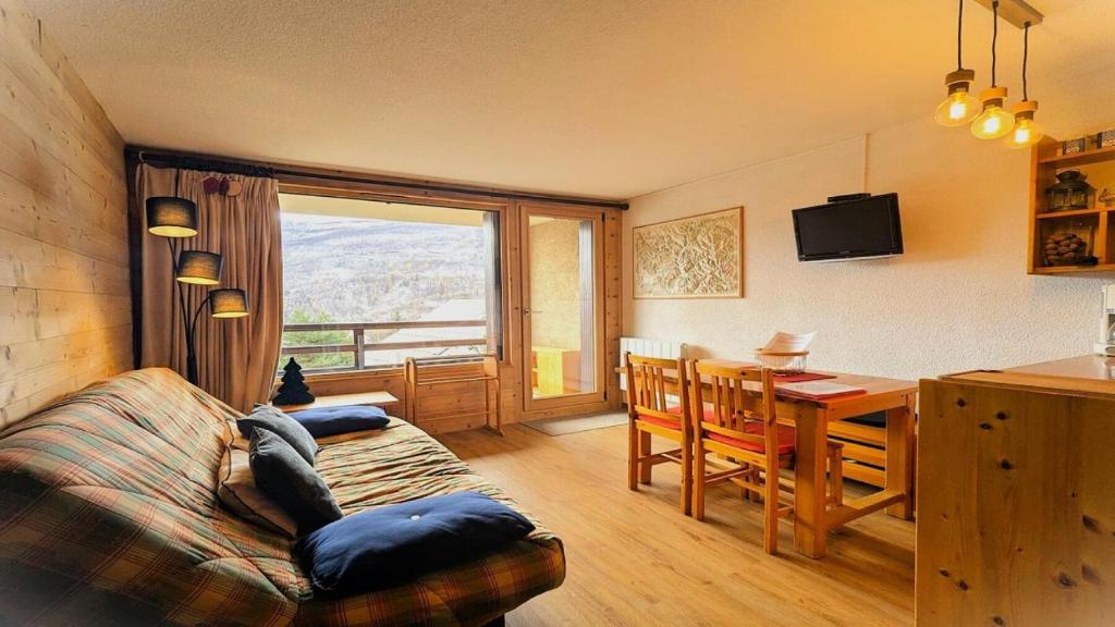 un salon avec un canapé et une table avec vue dans l'établissement Résidence Valérianes - Charmant appartement T2 avec balcon MAE-6921, à Vallouise