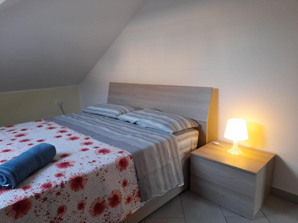 a bedroom with a bed and a lamp on a night stand at Splendid Mansarda Issiglio - BORGO SAN PAOLO - PARCO RUFFINI in Turin
