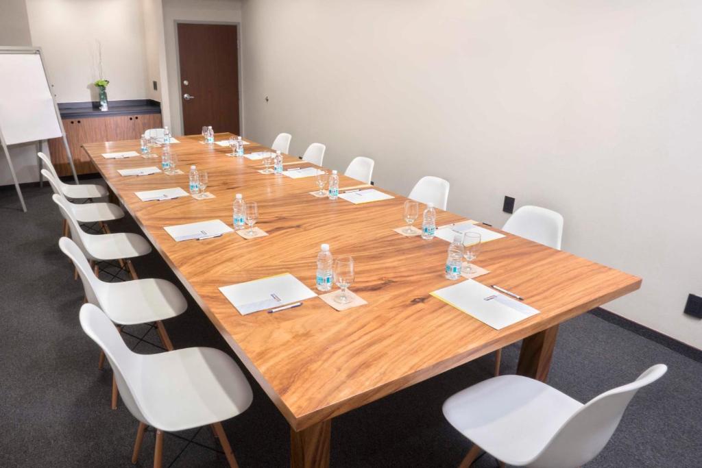 A private meeting room with a long wooden table and white chairs.