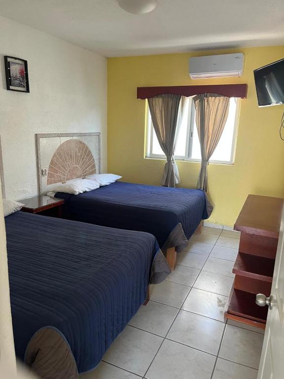 a hotel room with two beds and a window at Hotel Albatros Palace - Bungalow G in Manzanillo