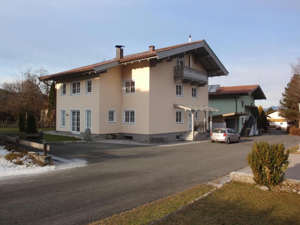 a house with a car parked on the side of the road at Appartmenthaus Aschaber in Westendorf