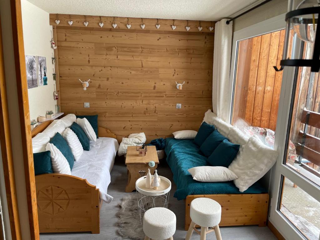un salon avec un canapé et une fenêtre dans l'établissement Lili Home Bellecôte - La Plagne, à La Plagne Tarentaise