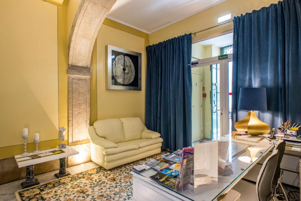 ein Wohnzimmer mit einem Stuhl und einem Glastisch in der Unterkunft PH Downtown Suites in Lissabon