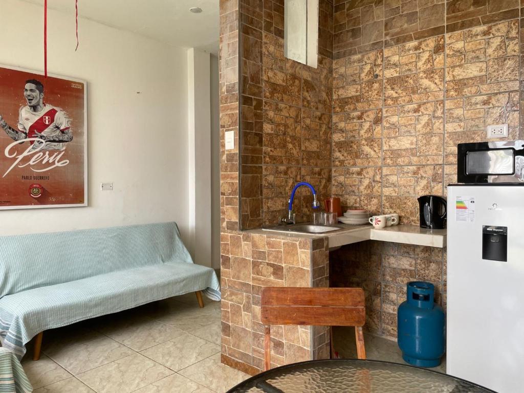 een keuken met een bank, een wastafel en een koelkast bij Olas inn in Asia