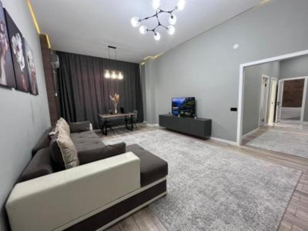 ein Wohnzimmer mit Sofa und Fernseher in der Unterkunft ЖК New City двухкомнатные уютная апартаменты in Atyrau