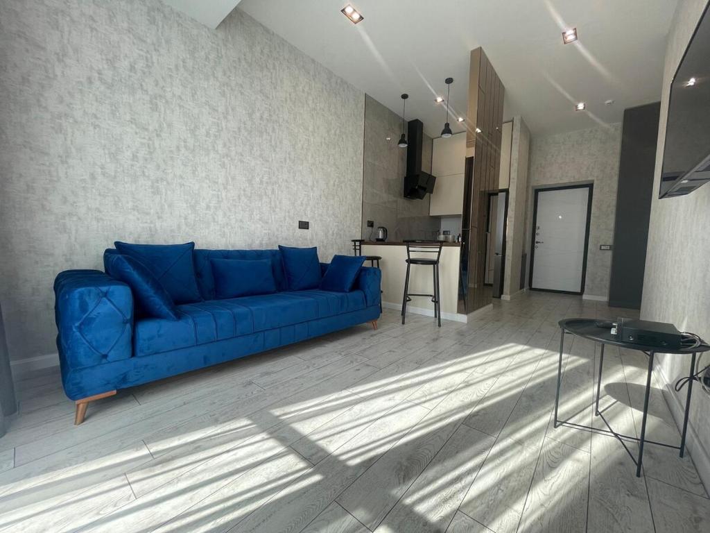 un soggiorno con un divano blu e una cucina di Sapphire Apartment a Baku