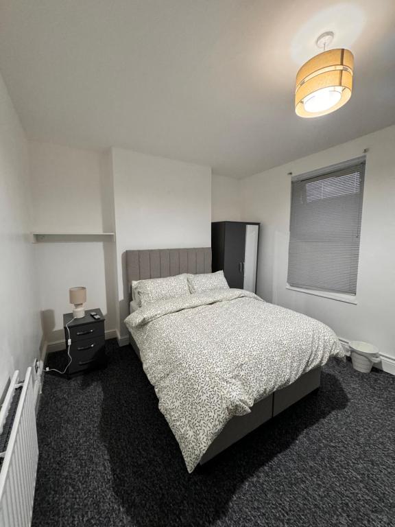 een witte slaapkamer met een bed en een lamp bij Oxborne Rooms UK - Plaistow in Londen