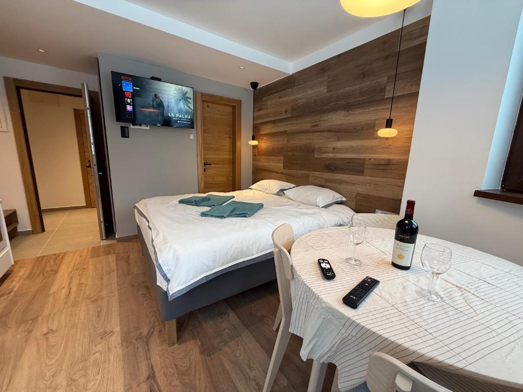 ein Schlafzimmer mit einem Bett und einem Tisch mit einer Flasche Wein in der Unterkunft Juli Kop in Kopaonik