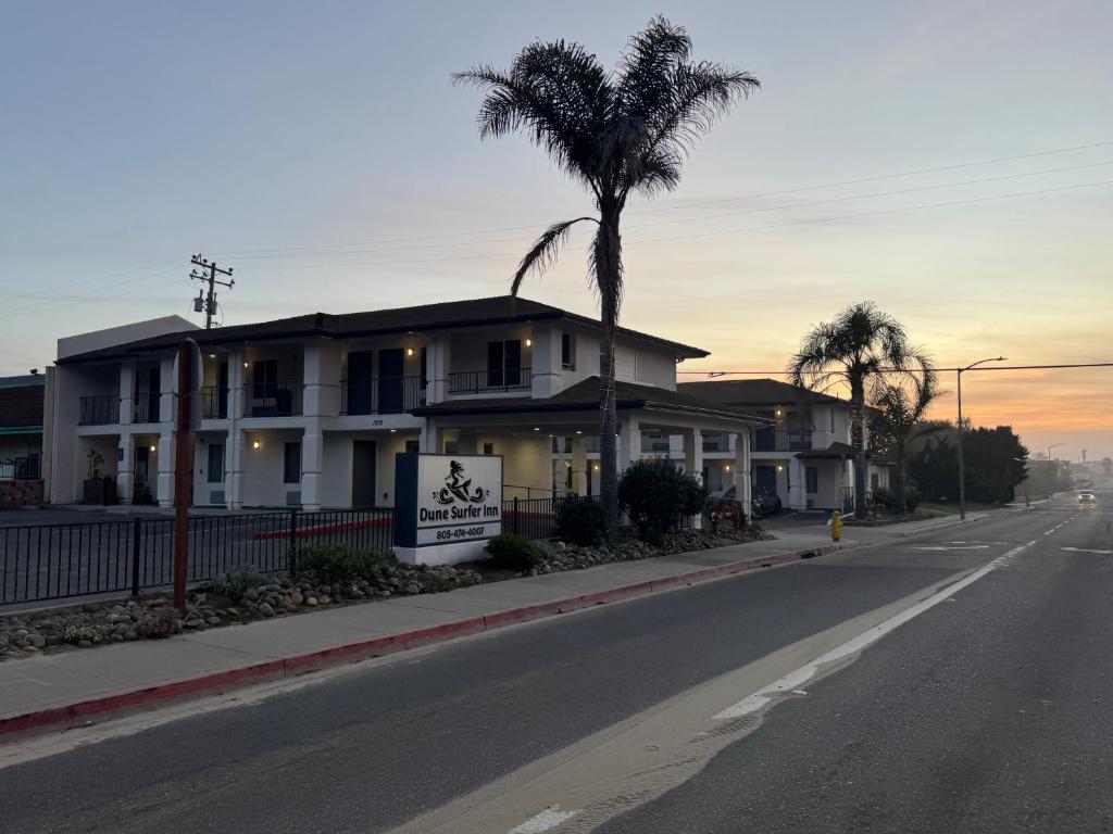 a palm tree in front of a house on a street at Dune Surfer Inn in Oceano