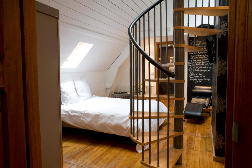 1 dormitorio con 1 cama y escalera de caracol en B&B Oeren-Plage, en Alveringem