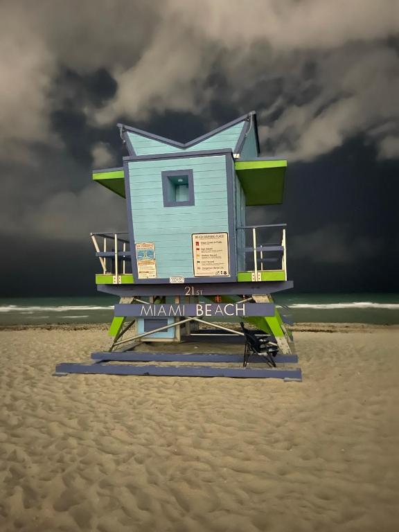 a blue lifeguard house on the beach with a storm at OQP Vacations in Miami