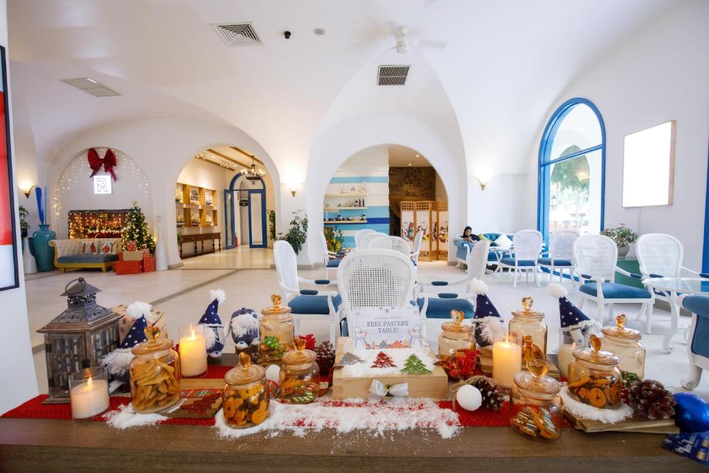 una stanza con sedie bianche e candele su un tavolo di Risemount Premier Resort Da Nang a Da Nang