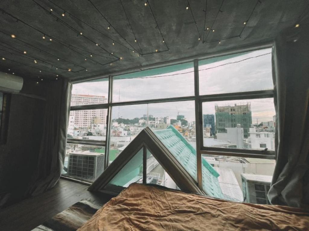 une chambre avec vue sur une ville depuis une fenêtre dans l'établissement Nhà Saigon Homestay&Coffee, à Hô-Chi-Minh-Ville