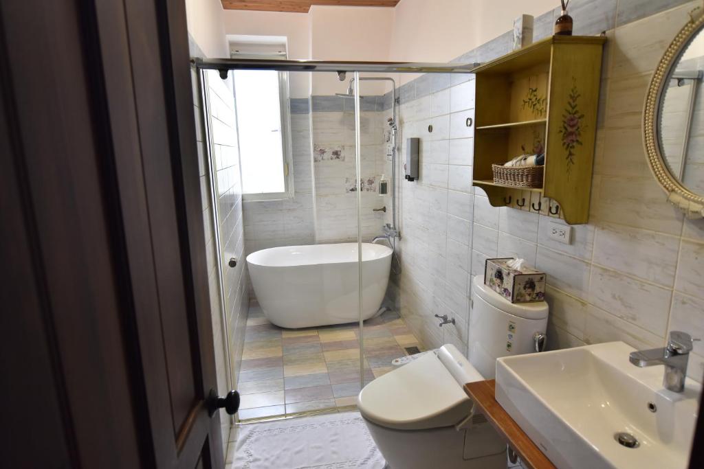 a bathroom with a tub and a toilet and a sink at Brulee's Done in Dongshan