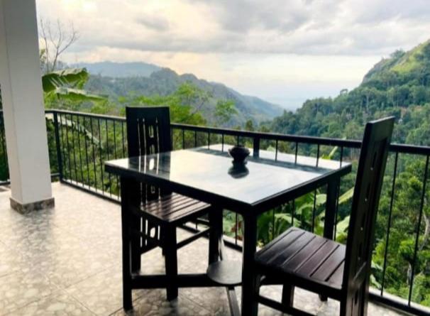 ein Tisch und zwei Stühle auf einem Balkon mit Aussicht in der Unterkunft Angel's View Cottage Ella in Ella