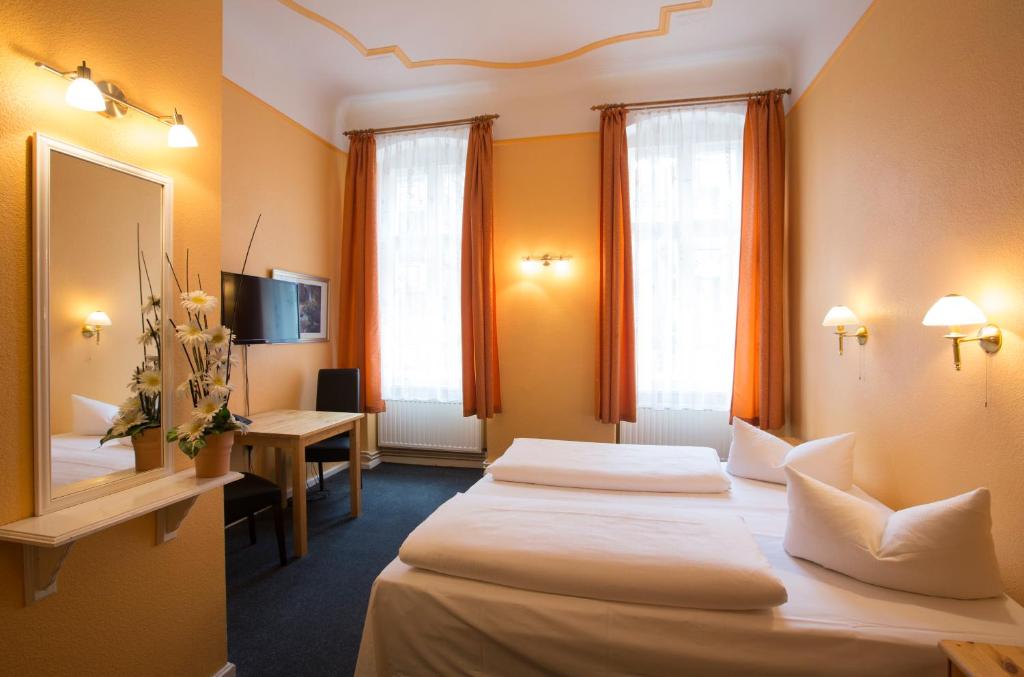 a hotel room with two beds and a desk at Hotel am Hermannplatz in Berlin