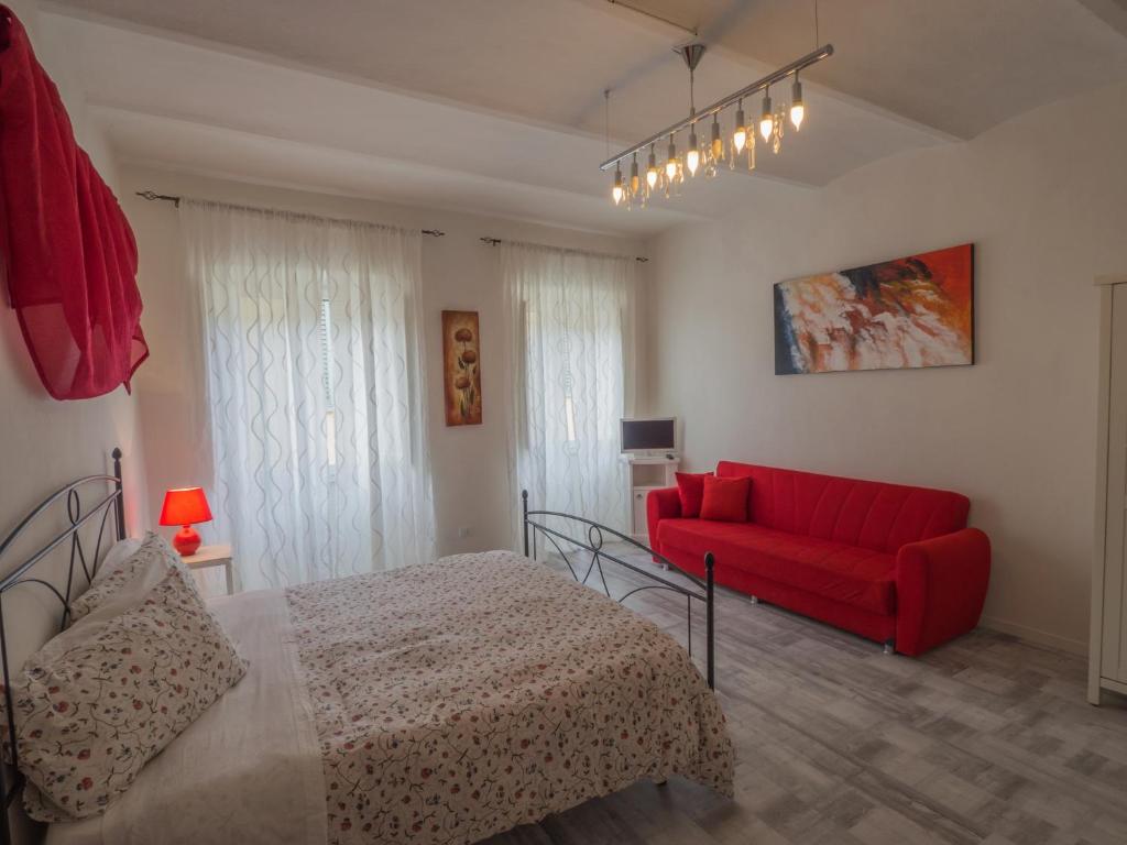una camera con un letto rosso e un divano rosso di La Pieve ad Arezzo