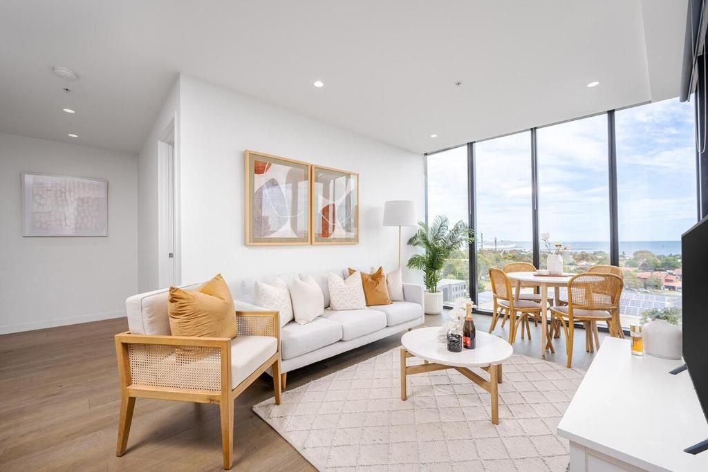 a living room with a couch and a table at Luxury Bay View Apartment in Melbourne