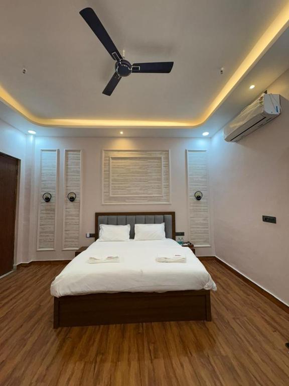 a bedroom with a bed with a ceiling fan at Rajpal Hotels in Orai