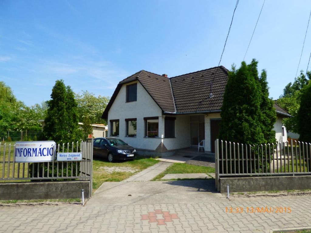 a house with a sign in front of it at Fábián Apartman-ház in Szántód