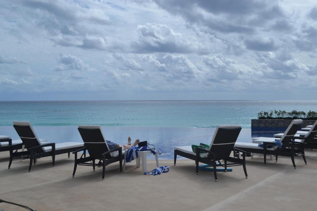 uma pessoa sentada numa mesa perto do oceano em Ocean View Condo em Cancún