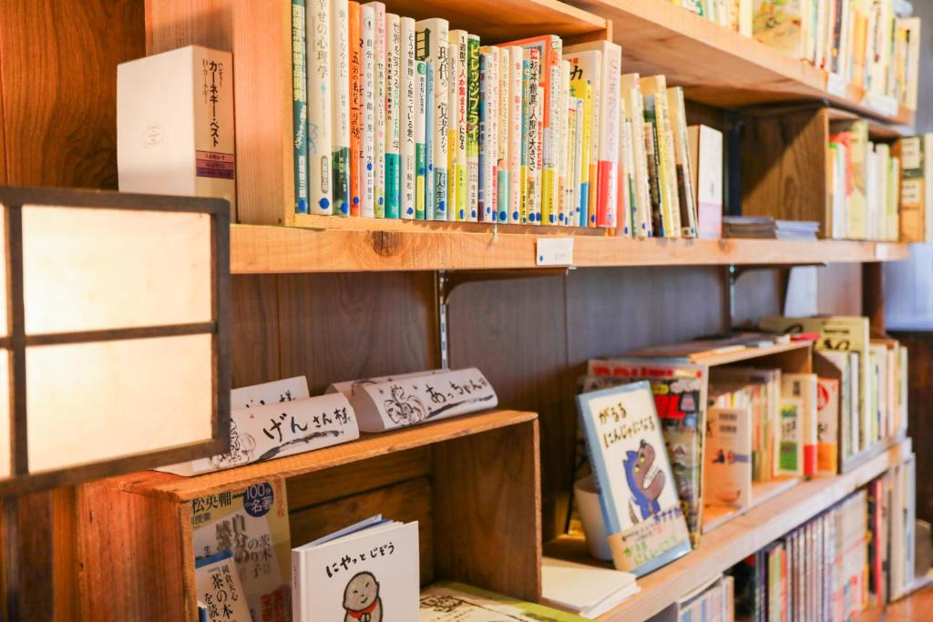 a book shelf filled with lots of books at Guesthouse SETOUCHI LIFE in Kure