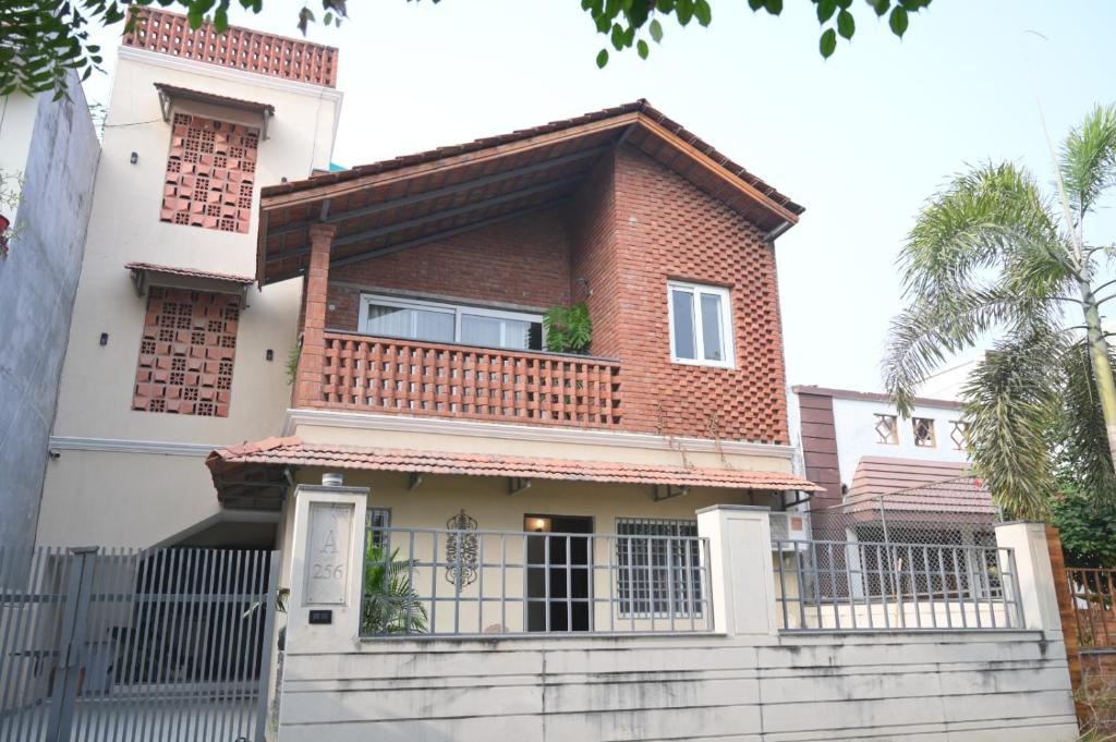 a house with a balcony on top of it at Red Brick Retreat G floor 3BHK in Lucknow