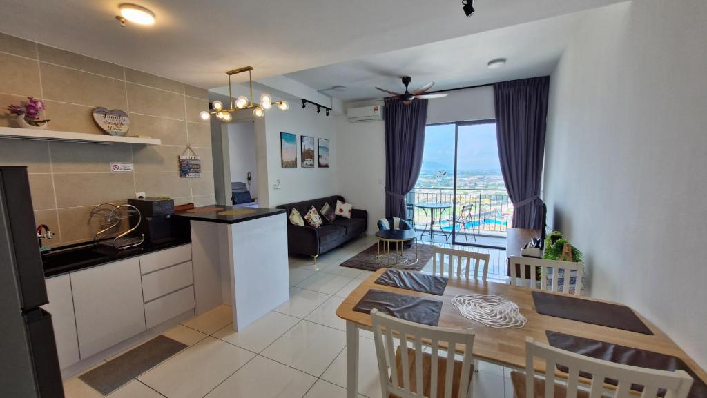 a kitchen and living room with a table and a couch at H&W Sunway Onsen Suite 4-7pax near Lost World of Tambun Ipoh in Ipoh