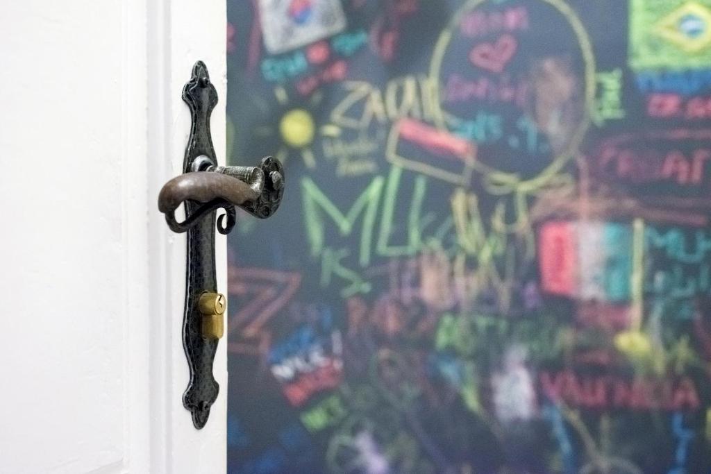 metalowa klamka drzwi przed ścianą z graffiti w obiekcie Apartment D2 4U w mieście Zadar
