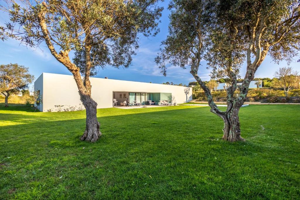 twee bomen voor een wit gebouw bij Vila D`Obidos in Casal da Lagoa Seca