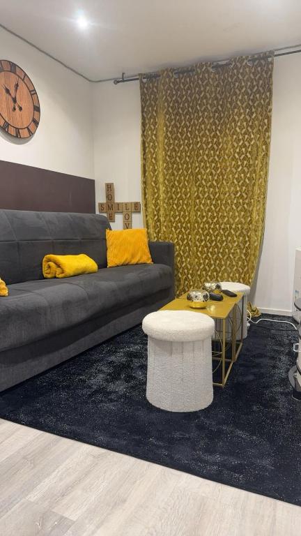 - un salon avec un canapé, une table et un réveil dans l'établissement Hébergement jacuzzi très silencieux, à Deuil-la-Barre