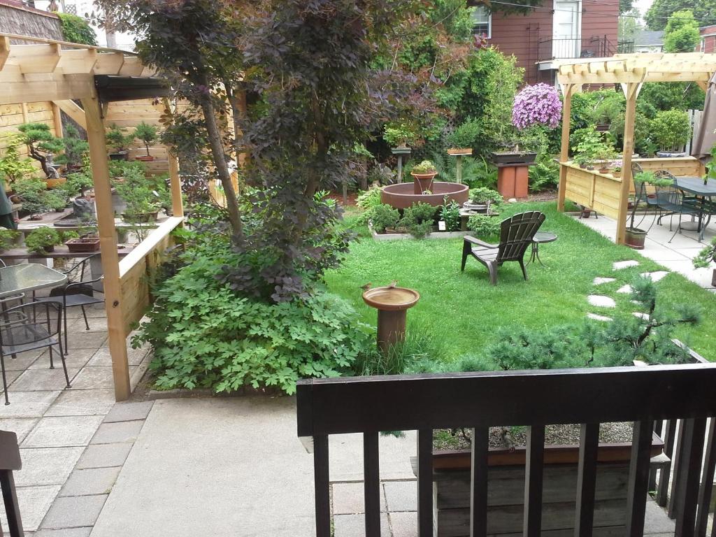 a backyard with a garden with a table and chairs at 3 Bedrooms 3 beds near metro -2 Parking Free in Montreal