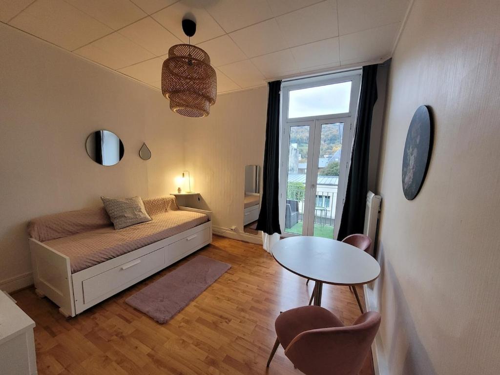 une chambre avec un lit, une table et une fenêtre dans l'établissement Charmant studio, à Bagnères-de-Bigorre